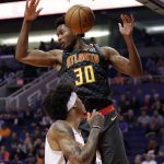 Atlanta Hawks center Damian Jones (30) dunks over Phoenix Suns forward Kelly Oubre Jr. during the first half of an NBA basketball game Thursday, Nov. 14, 2019, in Phoenix. (AP Photo/Matt York)