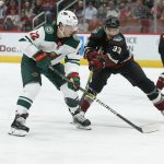 Minnesota Wild left wing Kevin Fiala (22) shoots on goal in front of Arizona Coyotes defenseman Alex Goligoski in the first period during an NHL hockey game, Saturday, Nov. 9, 2019, in Glendale, Ariz. (AP Photo/Rick Scuteri)