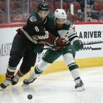 Arizona Coyotes center Nick Schmaltz (8) and Minnesota Wild left wing Jason Zucker fight for the puck in the second period during an NHL hockey game, Saturday, Nov. 9, 2019, in Glendale, Ariz. (AP Photo/Rick Scuteri)