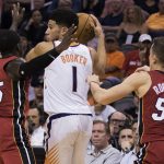 Phoenix Suns' Devin Booker (1) looks to pass as he is double-teamed by Miami Heat's Kendrick Dunn (25) and Duncan Robinson (55) during the second half of an NBA basketball game Thursday, Nov. 7, 2019, in Phoenix. (AP Photo/Darryl Webb)