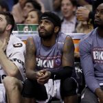 Brooklyn Nets guard Kyrie Irving, center, watches from the bench during the second half of the team's NBA basketball game against the Phoenix Suns, Sunday, Nov. 10, 2019, in Phoenix. (AP Photo/Matt York)