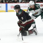 Arizona Coyotes center Clayton Keller (9) fights for the puck from his knees with Minnesota Wild center Eric Staal (12) in the second period during an NHL hockey game, Saturday, Nov. 9, 2019, in Glendale, Ariz. (AP Photo/Rick Scuteri)