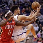 Phoenix Suns guard Devin Booker, right, tries to get control of the ball next to New Orleans Pelicans guard Jrue Holiday (11) during the second half of an NBA basketball game Thursday, Nov. 21, 2019, in Phoenix. (AP Photo/Matt York)