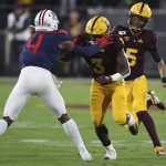 Arizona State quarterback Jayden Daniels (5) gets a block from his running back Eno Benjamin (3) against Arizona's Christian Roland-Wallace during the first half of an NCAA college football game, Saturday, Nov. 30, 2019, in Tempe, Ariz. (AP Photo/Darryl Webb)