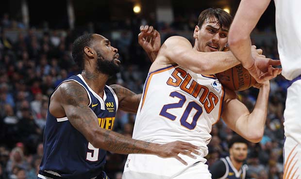 Phoenix Suns forward Dario Saric, right, pulls in a rebound as Denver Nuggets guard Will Barton def...