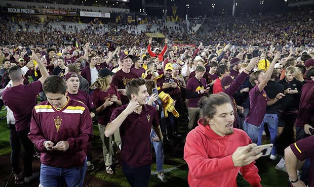 Arizona State fans rush the field after the team's NCAA college football game against Oregon, Satur...