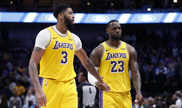 Los Angeles Lakers' Anthony Davis (3) and LeBron James (23) celebrate as they walk back to the benc...