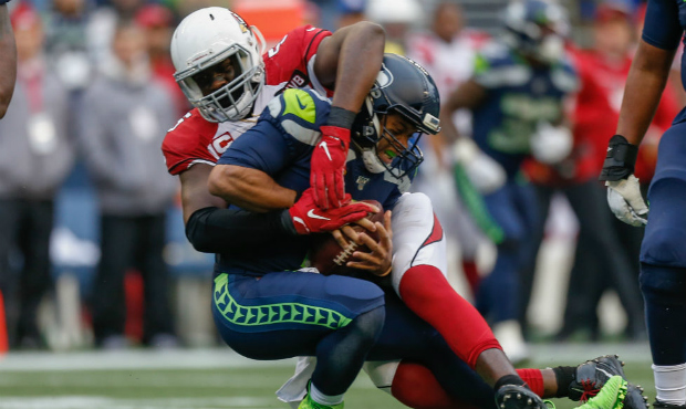 Quarterback Russell Wilson #3 of the Seattle Seahawks is sacked by linebacker Chandler Jones #55 of...