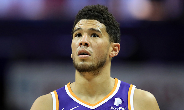 Devin Booker #1 of the Phoenix Suns watches on against the Charlotte Hornets during their game at S...