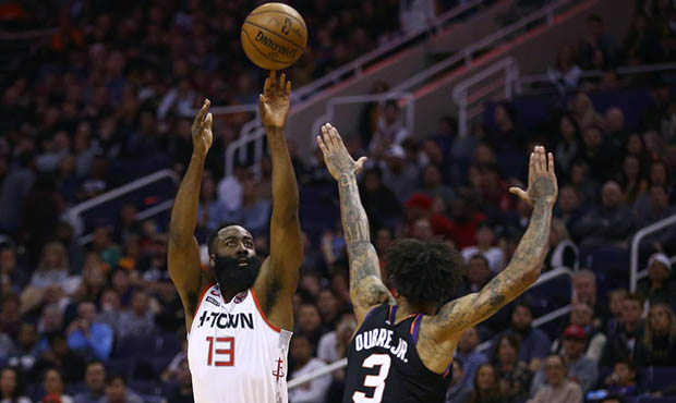 Houston Rockets guard James Harden (13) shoots over Phoenix Suns forward Kelly Oubre Jr. (3) during...