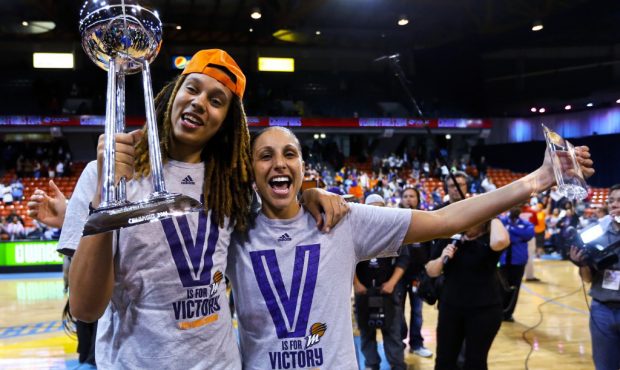 Phoenix Mercury's Brittney Griner, left, holds the WNBA championship trophy as she stands with Dian...