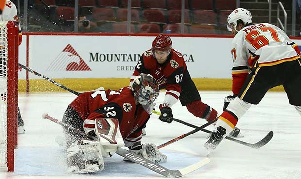 Calgary Flames right wing Michael Frolik (67) gets the puck past Arizona Coyotes goaltender Antti R...