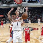 Phoenix Suns guard Devin Booker (1) dunks in front of New Orleans Pelicans forward Nicolo Melli during the first half of an NBA basketball game in New Orleans, Thursday, Dec. 5, 2019. (AP Photo/Gerald Herbert)
