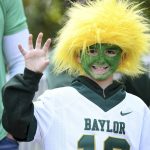 9-year-old Baylor fan Jhett Holmes flashes the "Sic 'Em" hand sign before the Big 12 Conference championship NCAA college football game between Baylor and Oklahoma on Saturday, Dec. 7, 2019, in Arlington, Texas. (AP Photo/Jeffrey McWhorter)
