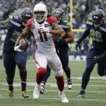 Arizona Cardinals wide receiver Larry Fitzgerald (11) runs for a touchdown after a reception as Seattle Seahawks defensive tackle Quinton Jefferson, left, and defensive end Rasheem Green, right, pursue during the first half of an NFL football game, Sunday, Dec. 22, 2019, in Seattle. (AP Photo/Elaine Thompson)