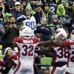 Seattle Seahawks fans react after Arizona Cardinals middle linebacker Jordan Hicks, lower left, recovered a fumble during the second half of an NFL football game, Sunday, Dec. 22, 2019, in Seattle. (AP Photo/Lindsey Wasson)