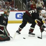 Arizona Coyotes defenseman Ilya Lyubushkin, middle, alters the shot by Chicago Blackhawks center Matthew Highmore (36) as Coyotes goaltender Darcy Kuemper (35) looks at the puck during the second period of an NHL hockey game Thursday, Dec. 12, 2019 in Glendale, Ariz. (AP Photo/Ross D. Franklin)