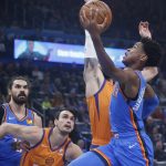 Oklahoma City Thunder guard Shai Gilgeous-Alexander, right, goes to the basket in front of teammate Steven Adams, left, and Phoenix Suns forward Dario Saric and guard Ricky Rubio during the first half of an NBA basketball game Friday, Dec. 20, 2019, in Oklahoma City. (AP Photo/Sue Ogrocki)