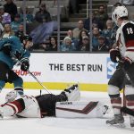 Arizona Coyotes goalie Darcy Kuemper (35) slides on the ice to block a shot from San Jose Sharks' Logan Couture, left, during the first period of an NHL hockey game Tuesday, Dec. 17, 2019, in San Jose, Calif. At right is Arizona's Christian Dvorak (18). (AP Photo/Ben Margot)