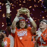 Clemson quarterback Trevor Lawrence holds up the trophy after Clemson's 29-23 win over Ohio State in the Fiesta Bowl NCAA college football playoff semifinal Saturday, Dec. 28, 2019, in Glendale, Ariz. (AP Photo/Rick Scuteri)