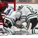 Dallas Stars goaltender Anton Khudobin, bottom, gets help making a save against a shot by Arizona Coyotes left wing Taylor Hall, left, from Stars centers Andrew Cogliano, second from left, and Radek Faksa (12) during the first period of an NHL hockey game Sunday, Dec. 29, 2019, in Glendale, Ariz. (AP Photo/Ross D. Franklin)