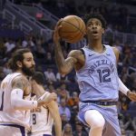 Memphis Grizzlies guard Ja Morant (12) drives past Phoenix Suns guard Ricky Rubio, left, during the first half of an NBA basketball game Wednesday, Dec. 11, 2019 in Phoenix. (AP Photo/Ross D. Franklin)