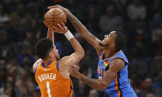 Oklahoma City Thunder guard Terrance Ferguson, right, blocks a shot by Phoenix Suns guard Devin Boo...