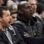 Actor Adam Sandler and NBA All Star Kevin Garnett watch during the first half of an NBA basketball game between the Los Angeles Clippers and the Phoenix Suns in Los Angeles, Tuesday, Dec. 17, 2019. (AP Photo/Chris Carlson)
