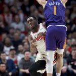 Portland Trail Blazers forward Nassir Little, left, passes the ball away from Phoenix Suns guard Devin Booker during the first half of an NBA basketball game in Portland, Ore., Monday, Dec. 30, 2019. (AP Photo/Craig Mitchelldyer)
