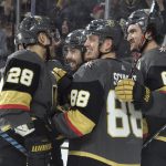 Vegas Golden Knights left wing William Carrier (28), defenseman Nate Schmidt (88), right wing Mark Stone (61) celebrate a goal by center Chandler Stephenson, second left, against the Arizona Coyotes during the second period of an NHL hockey game Saturday, Dec. 28, 2019, in Las Vegas. (AP Photo/David Becker)