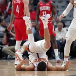 Phoenix Suns guard Devin Booker (1) rolls onto his back after shooting a 3-pointer during the first half of the team's NBA basketball game against the New Orleans Pelicans in New Orleans, Thursday, Dec. 5, 2019. (AP Photo/Gerald Herbert)