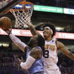 Phoenix Suns forward Kelly Oubre Jr., right, goes in for a blocked shot against Memphis Grizzlies forward Jae Crowder, left, during the first half of an NBA basketball game Wednesday, Dec. 11, 2019 in Phoenix. (AP Photo/Ross D. Franklin)