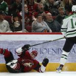 Dallas Stars left wing Jamie Benn (14) sends Arizona Coyotes left wing Lawson Crouse (67) to the ice on a check during the first period of an NHL hockey game Sunday, Dec. 29, 2019, in Glendale, Ariz. (AP Photo/Ross D. Franklin)