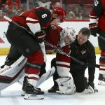 Arizona Coyotes goaltender Darcy Kuemper, middle, is helped off the ice by defenseman Jakob Chychrun (6) and head athletic trainer Dave Zenobi, right, after an injury during the third period of the team's NHL hockey game against the Minnesota Wild on Thursday, Dec. 19, 2019, in Glendale, Ariz. The Wild defeated the Coyotes 8-5. (AP Photo/Ross D. Franklin)