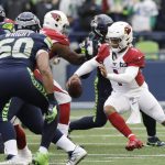 Arizona Cardinals quarterback Kyler Murray, right, keeps the ball away from the Seattle Seahawks during the first half of an NFL football game, Sunday, Dec. 22, 2019, in Seattle. (AP Photo/Elaine Thompson)
