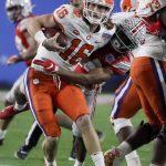 Ohio State cornerback Shaun Wade, right, tackles Clemson quarterback Trevor Lawrence during the first half of the Fiesta Bowl NCAA college football playoff semifinal Saturday, Dec. 28, 2019, in Glendale, Ariz. Wade was ejected from the game for targeting. (AP Photo/Rick Scuteri)