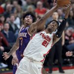 Portland Trail Blazers center Hassan Whiteside, right, and Phoenix Suns forward Kelly Oubre Jr. vie for a rebound during the second half of an NBA basketball game in Portland, Ore., Monday, Dec. 30, 2019. (AP Photo/Craig Mitchelldyer)