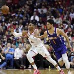 Houston Rockets' Russell Westbrook (0) and Phoenix Suns' Devin Booker (1) reach for a loose ball during the first half of an NBA basketball game Saturday, Dec. 7, 2019, in Houston. (AP Photo/David J. Phillip)