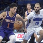Phoenix Suns guard Devin Booker (1) drives to the basket in front of Orlando Magic guard Evan Fournier (10) during the first half of an NBA basketball game Wednesday, Dec. 4, 2019, in Orlando, Fla. (AP Photo/Phelan M. Ebenhack)