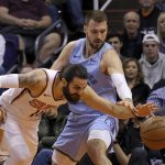 Phoenix Suns guard Ricky Rubio, left, battles with Memphis Grizzlies guard Marko Guduric, right, for the loose ball during the first half of an NBA basketball game Wednesday, Dec. 11, 2019 in Phoenix. (AP Photo/Ross D. Franklin)