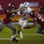 Air Force running back Kadin Remsberg (24) runs between Washington State linebacker Jahad Woods (13) and Skyler Thomas (25) in the second half during the Cheez-It Bowl NCAA college football game, Friday, Dec. 27, 2019, in Phoenix. Air Force defeated Washington State 31-21. (AP Photo/Rick Scuteri)