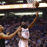 Houston Rockets guard James Harden (13) drives past Phoenix Suns forward Elie Okobo (2) to score during the first half of an NBA basketball game Saturday, Dec. 21, 2019, in Phoenix. (AP Photo/Ross D. Franklin)