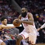 Houston Rockets' James Harden (13) drives toward the basket as Phoenix Suns' Ricky Rubio (11), Devin Booker (1) and Frank Kaminsky III, left, defend during the first half of an NBA basketball game Saturday, Dec. 7, 2019, in Houston. (AP Photo/David J. Phillip)