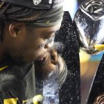 Oregon cornerback Haki Woods Jr. (14) kisses the trophy after Oregon defeated Utah 37-15 in an NCAA college football game for the Pac-12 Conference championship in Santa Clara, Calif., Friday, Dec. 6, 2018. (AP Photo/Tony Avelar)