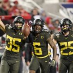 Oregon linebacker Troy Dye (35) celebrates with teammates Deommodore Lenoir (6) and Brady Breeze (25) after Dye intercepted a Utah pass during the second half of an NCAA college football game for the Pac-12 Conference championship in Santa Clara, Calif., Friday, Dec. 6, 2018. Oregon won 37-15. (AP Photo/Tony Avelar)