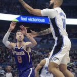 Orlando Magic guard Evan Fournier (10) goes up for a shot in front of Phoenix Suns forward Frank Kaminsky (8) during the first half of an NBA basketball game Wednesday, Dec. 4, 2019, in Orlando, Fla. (AP Photo/Phelan M. Ebenhack)