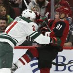 Arizona Coyotes left wing Taylor Hall (91) gets shoved by Minnesota Wild defenseman Carson Soucy, left, during the first period of an NHL hockey game Thursday, Dec. 19, 2019, in Glendale, Ariz. (AP Photo/Ross D. Franklin)