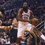 Houston Rockets guard James Harden (13) looks to pass the ball as he gets past Phoenix Suns center Aron Baynes, left, and guard Devin Booker, second from left, during the first half of an NBA basketball game Saturday, Dec. 21, 2019, in Phoenix. (AP Photo/Ross D. Franklin)