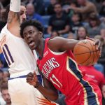 New Orleans Pelicans guard Jrue Holiday, rihgt, drives against Phoenix Suns guard Ricky Rubio during the first half of an NBA basketball game in New Orleans, Thursday, Dec. 5, 2019. (AP Photo/Gerald Herbert)
