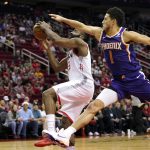 Houston Rockets' James Harden (13) goes up for a shot as Phoenix Suns' Devin Booker (1) reaches to foul him during the first half of an NBA basketball game Saturday, Dec. 7, 2019, in Houston. (AP Photo/David J. Phillip)